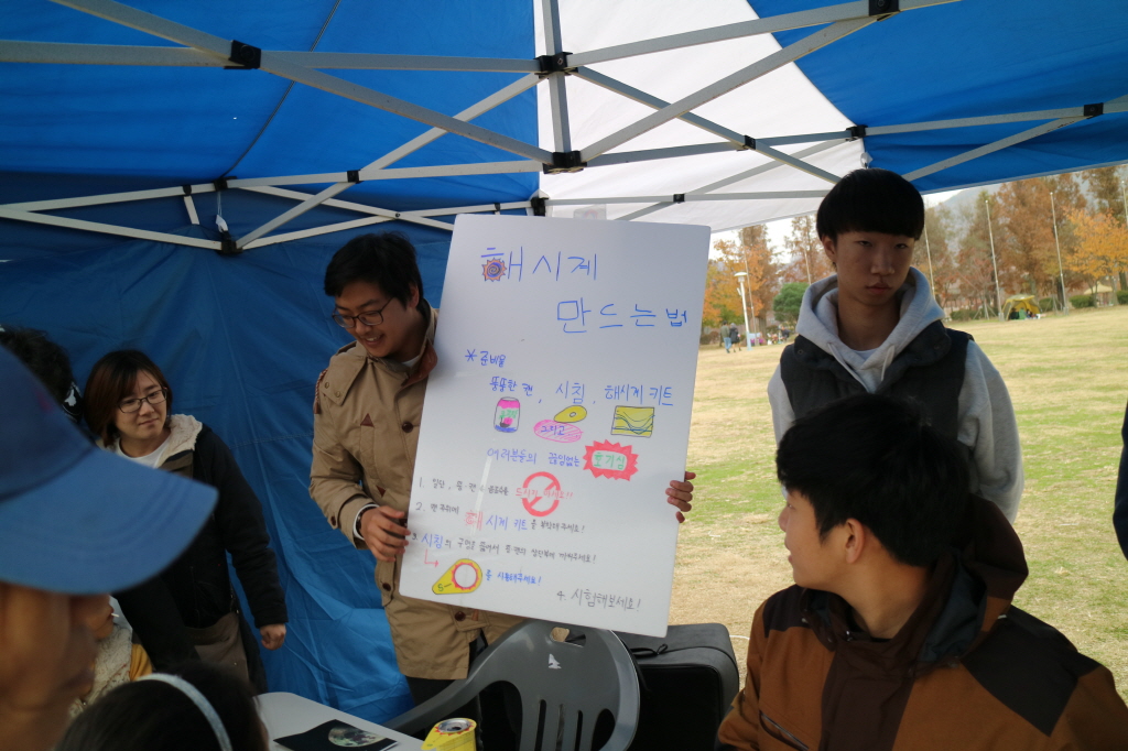 부스 활동 모습, 해시계 만드는 법에 대한 판넬을 보며 이야기하는 모습